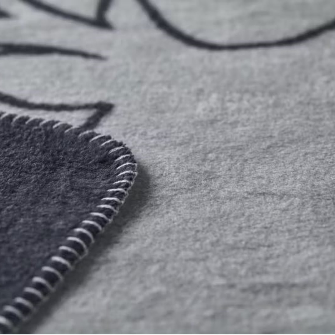 David Fussenegger Savona Kuscheldecke Hirschköpfe linear GRS anthrazit Detail Ketteleinfassung