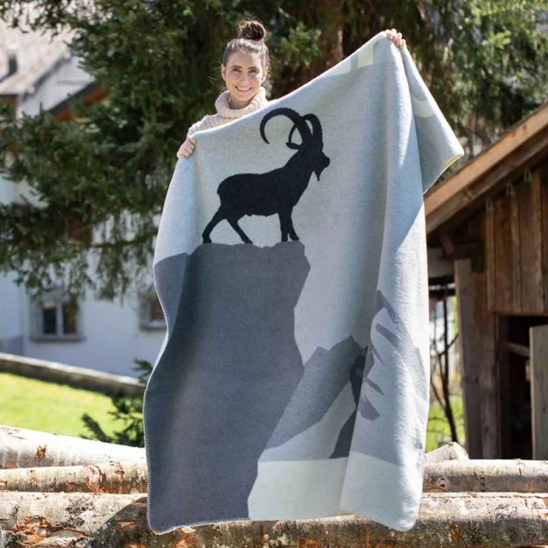 Savona Wohndecke Steinbockvon David Fussenegger wird von einem Mädchen gehalten