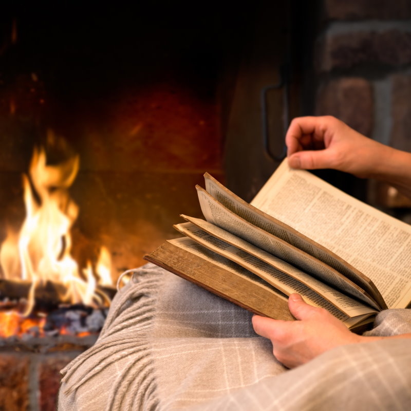 natürliche Wolldecke mit Kaminfeuer und Buch entspannter Feierabend